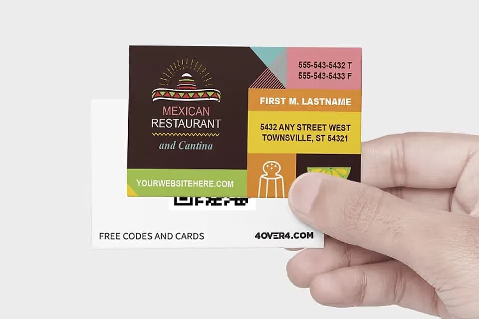 Hand holding a free business card for a Mexican restaurant, with the QR code back behind it